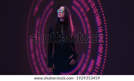 Beautiful stylish woman on dark virtual reality background. Cryptocurrency, finance, future technology, innovative ideas, cyberpunk concept. Futuristic holographic interface to display data.