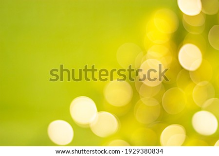 bokeh, defocused, blurry lights in the lower right corner on a yellow-green background