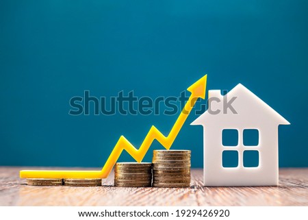 Real estate market, graph, up arrow. House model and a stack of coins. The concept of inflation, economic growth, the price of insurance services Royalty-Free Stock Photo #1929426920