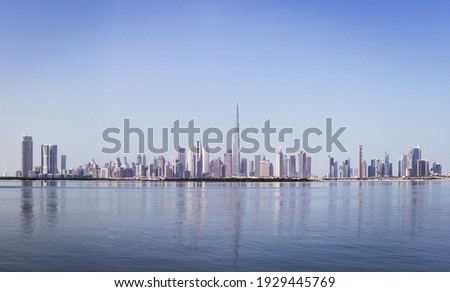 Dubai Downtown skyline panorama with reflections in Dubai Creek, cold colors, seen from Dubai Creek Harbour promenade. Royalty-Free Stock Photo #1929445769