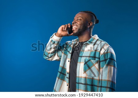 Handsome black man talking on the mobile happy and smiling.