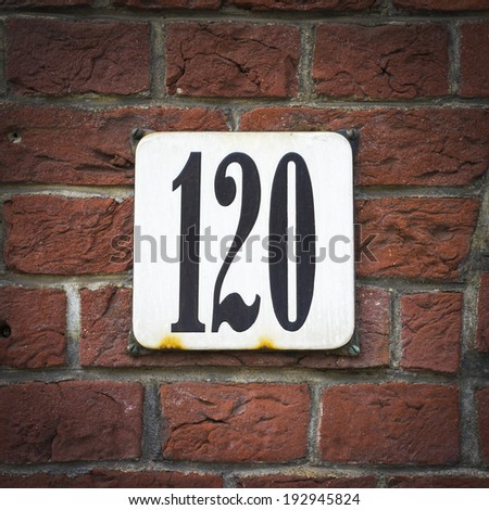 enameled house number on a red brick wall