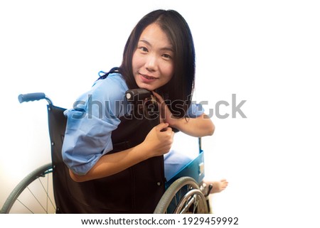 portrait of young happy and positive Asian Korean woman in hospital gown sitting on wheelchair recovering from injury or disease smiling cheerful while healing isolated on white