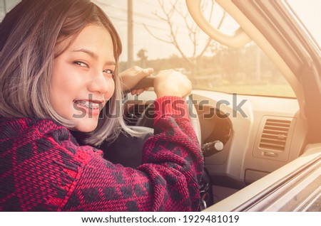 Close-up pictures of Asian women driving in a confident mood. Focus on face