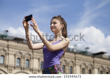 Happy young woman taking pictures on your phone