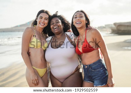 Happy multiracial women with different bodies and skins having fun in summer day on the beach - Main focus on center girl face