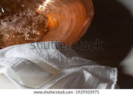 Copper water basin with white linen close up Royalty-Free Stock Photo #1929503975
