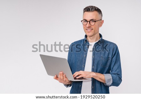 Confident good-looking mature man using laptop isolated over white background