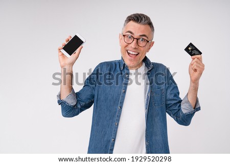 Happy middle-aged man with credit card and smart phone isolated over white background