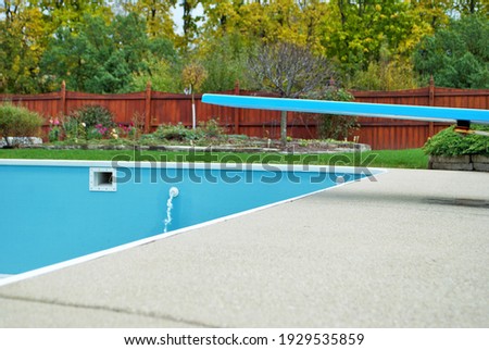 backyard swimming pool with diving board emptied out shutting down for winter