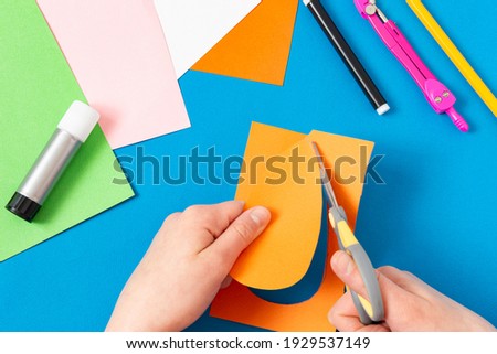 Child makes Easter greeting card. Art project for children. DIY concept. Step-by-step photo instruction. Step 3. Cut carrot