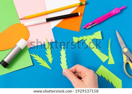 Child makes Easter greeting card. Art project for children. DIY concept. Step-by-step photo instruction. Step 5. Cut carrot stems