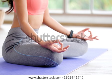 Close up of woman practice yoga meditation exercise at home, Young female sitting on mat for relaxed yoga posture in the morning , exercise at home, wellbeing, mental health care Royalty-Free Stock Photo #1929541742