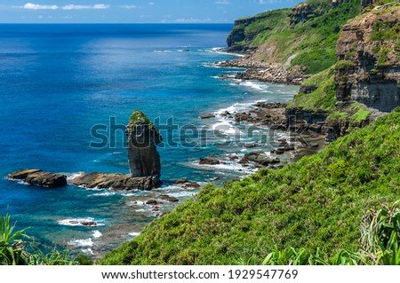 Spectacular hillside scenery. Tategami Rock, an impressive crystalline blue sea, coastal vegetation, waves on rocks. Yonaguni Island. Royalty-Free Stock Photo #1929547769