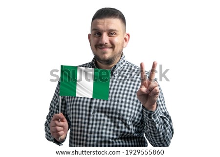 White guy holding a flag of Nigeria and shows two fingers isolated on a white background.
