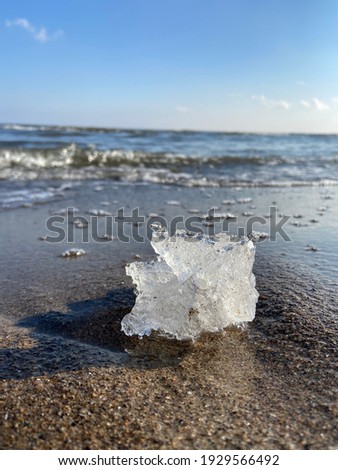 A picture of ice at the edge of a lake
With waves forming in the background.