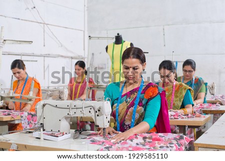 Woman textile worker using sewing machine on production line