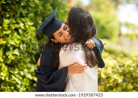 Proud mother hugging her daugher at her graduation Royalty-Free Stock Photo #1929587423