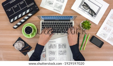 The hands of the men sort out the storyboards. A top view of the work desktop Royalty-Free Stock Photo #1929597020