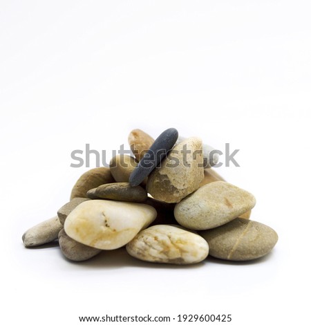 A closeup shot of a pile of pebbles isolated on the white background Royalty-Free Stock Photo #1929600425