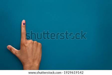 male Indian Voter Hand with voting sign or ink pointing vote for India on background with copy space election commission of India