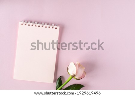 Copy space notepad for your text on a light pink background with pink roses. flat lay, Top view