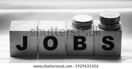 Jobs word Word Written In Wooden Cubes and coins. Business concept.