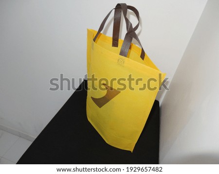 Yellow Color Mockup Bag, Handle Loop Non woven Printed Bag, Eco Bag isolated on Black Table