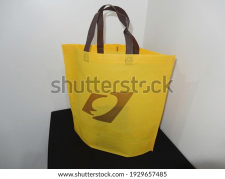 Yellow Color Mockup Bag, Handle Loop Non woven Printed Bag, Eco Bag isolated on Black Table
