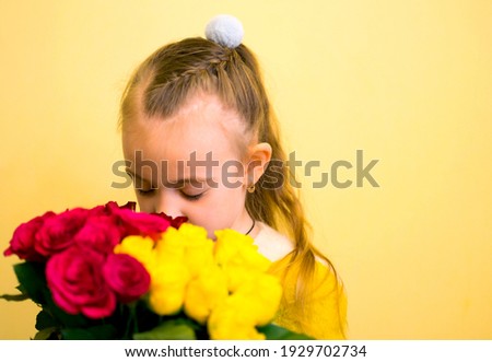 Little girl hugging a bouquet of roses. Image with selective focus