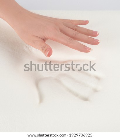 Orthopedic pillow, memory foam. Handprint on the pillow. Comfortable bedding with orthopedic, therapeutic effect. Memory foam material. Royalty-Free Stock Photo #1929706925