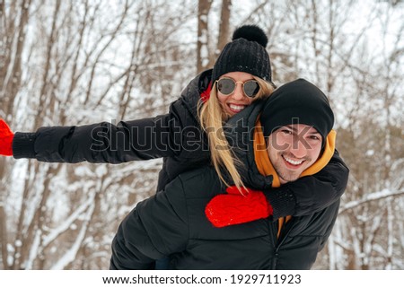 Happy couple hugging and smiling outdoors in snowy park