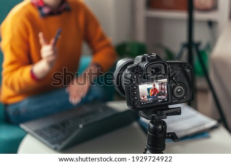 Woman coach or psychologist conducts online conference and records video on the camera for blog at home Royalty-Free Stock Photo #1929724922