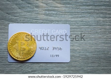 Credit card and Bitcoin on wood table background