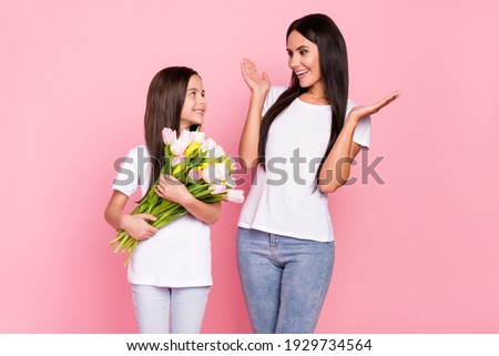 Photo portrait of little girl giving tulips bunch to her amazed mother on 8 march isolated pastel pink color background