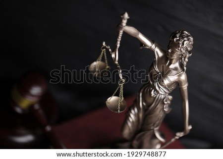 The Statue of Justice - lady justice or justitia the Roman goddess of Justice. Statue on brown book with judge gavel. Concept of judicial trial, courtroom process and lawyers occupation