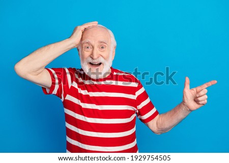 Photo of impressed old grey hairdo man point empty space wear red t-shirt isolated on bright blue color background