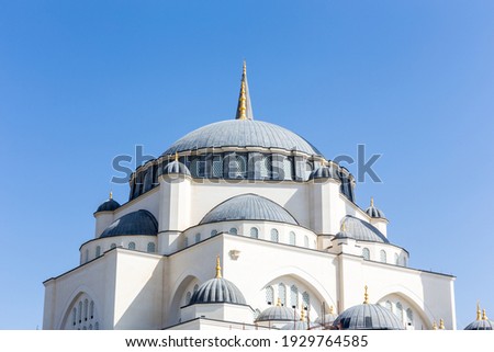 Dome of Sharjah Masjid mosque, The New Sharjah Mosque, the largest mosque in the Emirate of Sharjah, the United Arab Emirates, white sandstone facade with arched windows. Royalty-Free Stock Photo #1929764585