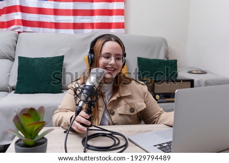 American young girl live streaming with her laptop. USA flack in the background. Vlogger concept.