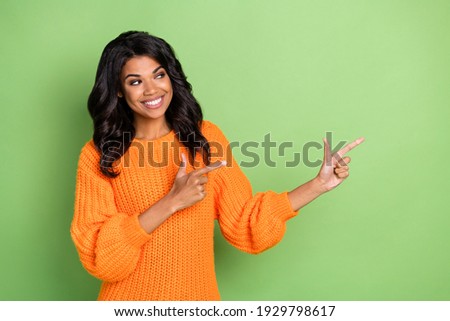 Portrait of attractive curious cheerful girl demonstrating ad copy space new novelty isolated over green pastel color background