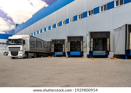 Truck while loading in a big distribution warehouse with gates for for loading goods and trucks  Royalty-Free Stock Photo #1929800954