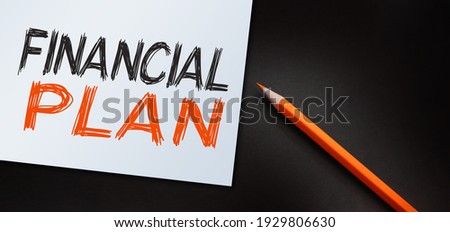 Financial plan text written on notebook and orange pencil. Business concept.