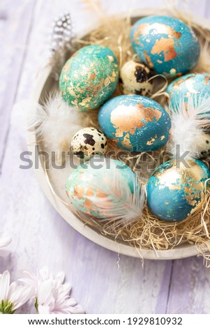 Blue Easter eggs on purple wooden table background