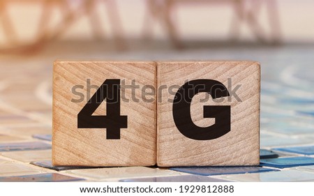 4G letters on wooden cubes standing on mosaic borber of swimming pool and beach landscape. Fast internet connection technology concept.