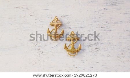 Gold anchors from navy uniforms. The concept of the day of the navy, sea travel, tourism. Closeup view