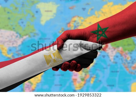 Handshake between egypt  and morocco flags painted on hands, illustration with clipping path.
