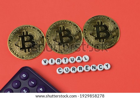 Calculator, golden bitcoins and alphabet beads with text VIRTUAL CURRENCY.