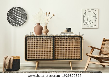 Stylish scandinavian living room interior of modern apartment with wooden commode, design armchair, carpet, leaf in vase, book and personal accessories in unique home decor. Template. Royalty-Free Stock Photo #1929872399
