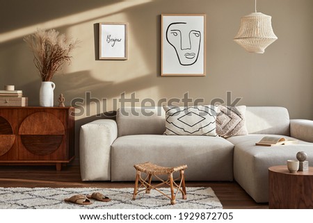 Interior design of cozy living room with stylish sofa, coffee table, dired flowers in vase, mock up poster, carpet, decoration, pillows, plaid and personal accessories in modern home decor. Template.