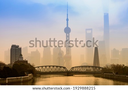 Shanghai Financial Center and modern skyscraper city in misty gold lighting sunrise behind pollution haze, view from the bund in Shanghai, China. vintage picture style 